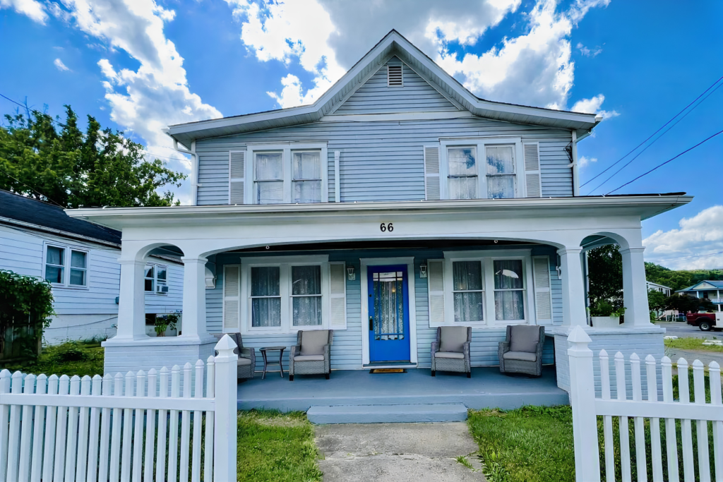 Historic 1889 Heritage Trail Inn exterior with welcoming front porch and white picket fence in Paw Paw, West Virginia